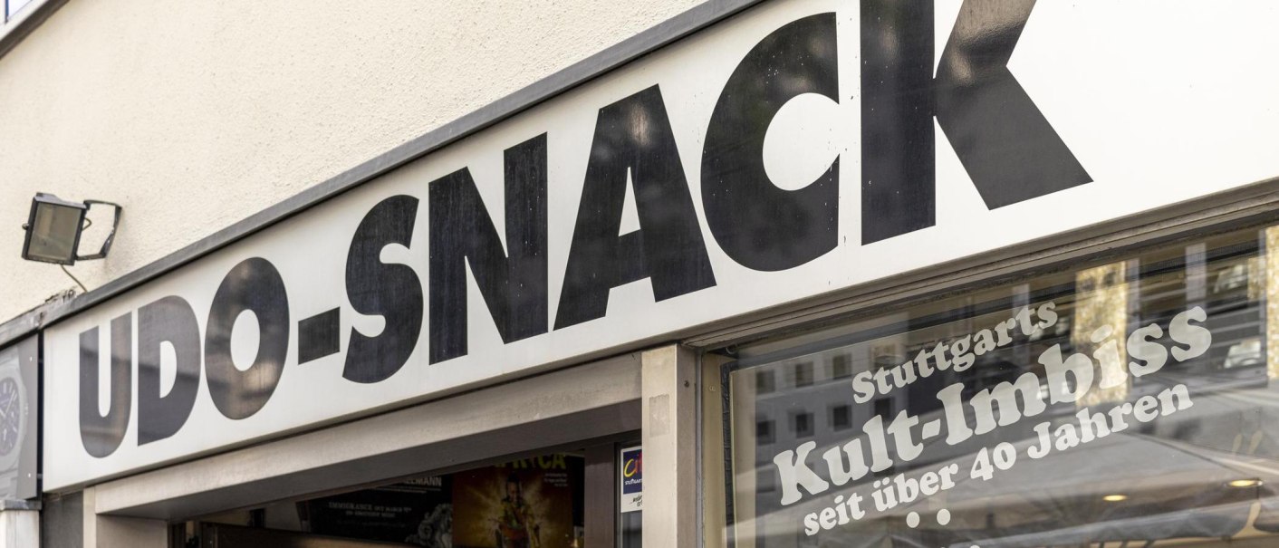 Schild mit der Aufschrift 'UDO-SNACK', darunter 'Stuttgarts Kult-Imbiss seit über 40 Jahren'. Außenansicht eines Imbissladens., © SMG, Sarah Schmid Schild mit der Aufschrift 'UDO-SNACK', darunter 'Stuttgarts Kult-Imbiss seit über 40 Jahren'. Außenansicht eines Imbissladens., © SMG, Sarah Schmid