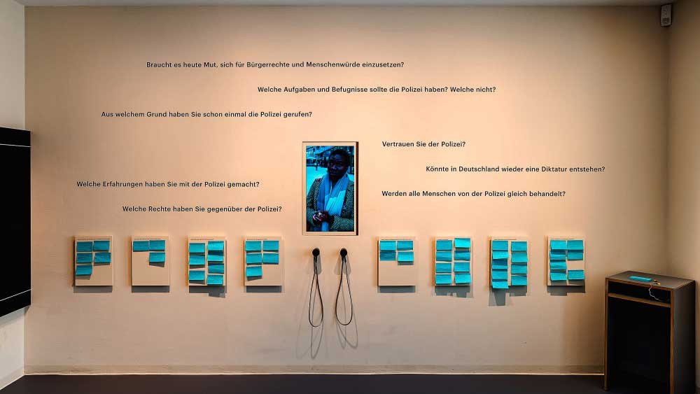 Ausstellungswand mit Fragen zur Polizei und Bürgerrechten, Notizen und Kopfhörern. Besucher können ihre Gedanken aufschreiben und anhören., © Haus der Geschichte Baden-Württemberg Ausstellungswand mit Fragen zur Polizei und Bürgerrechten, Notizen und Kopfhörern. Besucher können ihre Gedanken aufschreiben und anhören., © Haus der Geschichte Baden-Württemberg