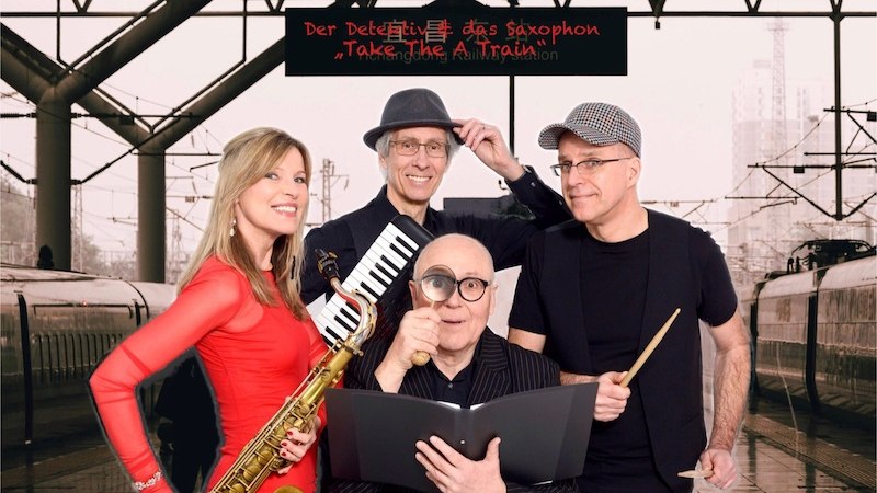 Vier Personen mit Musikinstrumenten stehen in einem Bahnhof. Eine Frau h&auml;lt ein Saxophon, w&auml;hrend die M&auml;nner eine Melodica, ein Buch und einen Trommelstock haben., &copy; Rosenau Kultur e.V.