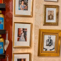 Regale mit Teedosen von 'The English Tearoom' und gerahmte Fotos an einer dekorativen Wand., © Tea Room, Stuttgart