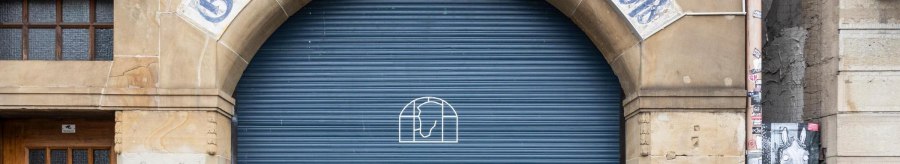 Eingang mit der Aufschrift 'Gastst&auml;tte zum wei&szlig;en Ro&szlig;' &uuml;ber einem blauen Rolltor. Daneben eine Holzt&uuml;r mit 'Card Only'-Schild., &copy; Stuttgart-Marketing GmbH, Sarah Schmid