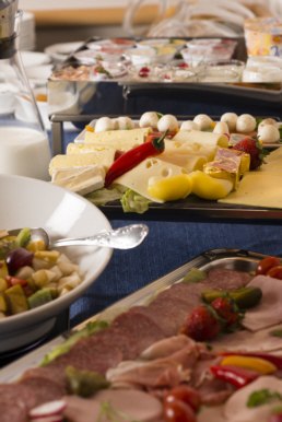 Ein Buffet mit verschiedenen Käsesorten, Wurstaufschnitt und einem Salat in einer Schüssel. Im Hintergrund sind weitere Speisen zu sehen., © Hotel Adler Waiblingen Ein Buffet mit verschiedenen Käsesorten, Wurstaufschnitt und einem Salat in einer Schüssel. Im Hintergrund sind weitere Speisen zu sehen., © Hotel Adler Waiblingen