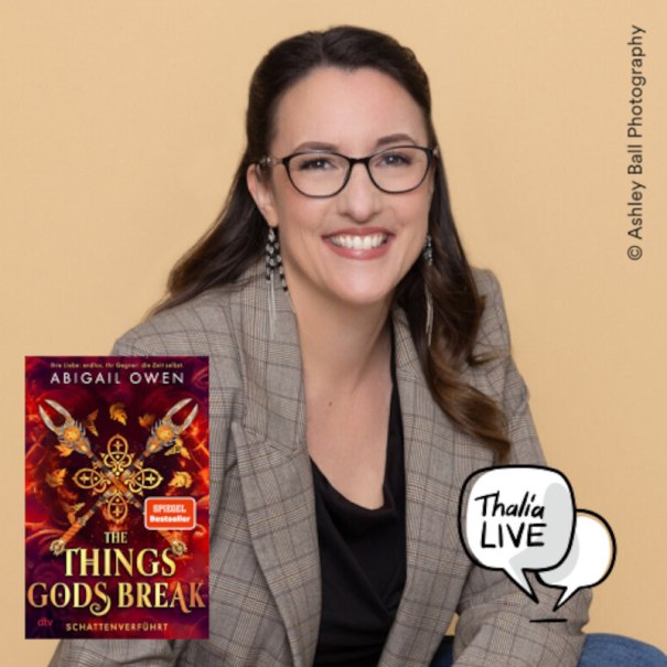 Eine l&auml;chelnde Frau mit Brille und kariertem Blazer sitzt vor einem beigen Hintergrund. Neben ihr ist das Buchcover von "The Things Gods Break - Schattenverf&uuml;hrt" abgebildet., &copy; Thalia Deutschland GmbH & Co. KG