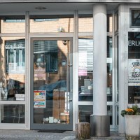 Entrance to a building with glass doors on which 'ERLKOENIG' is written. Posters and plants are visible. Modern architecture with a brick façade., © SMG Stuttgart Marketing GmbH - Sarah Schmid Entrance to a building with glass doors on which 'ERLKOENIG' is written. Posters and plants are visible. Modern architecture with a brick façade., © SMG Stuttgart Marketing GmbH - Sarah Schmid
