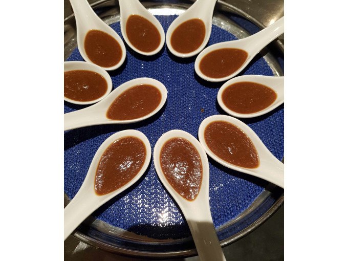White spoons with brown sauce are arranged in a circle on a blue tray., © Kultweine-Kochwelten-Kunstücke - Kochschule Sonja Lenz White spoons with brown sauce are arranged in a circle on a blue tray., © Kultweine-Kochwelten-Kunstücke - Kochschule Sonja Lenz