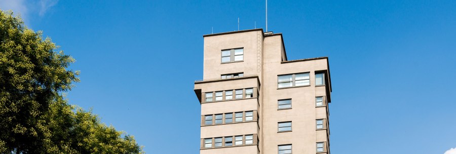 Der Tagblatt-Turm in Stuttgart erhebt sich vor einem klaren blauen Himmel, umgeben von grünen Bäumen., © TMBW, Gregor Lengler Der Tagblatt-Turm in Stuttgart erhebt sich vor einem klaren blauen Himmel, umgeben von grünen Bäumen., © TMBW, Gregor Lengler