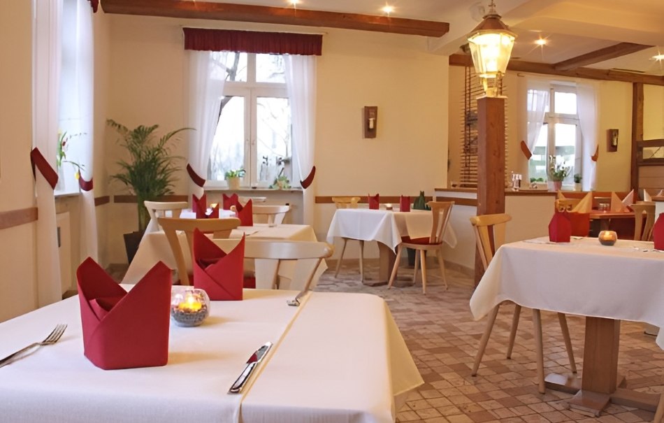 Cozy restaurant with white tablecloths, red napkins and candlelight. Wooden furniture and plants create an inviting atmosphere., © Hotel Neuwirtshaus Cozy restaurant with white tablecloths, red napkins and candlelight. Wooden furniture and plants create an inviting atmosphere., © Hotel Neuwirtshaus