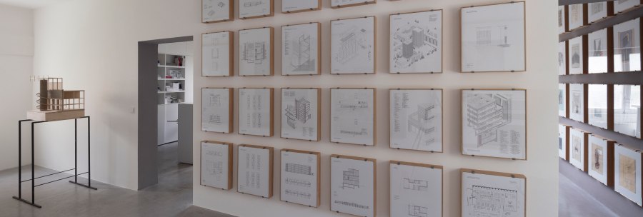 Ausstellungsraum mit Architekturzeichnungen in Holzrahmen, Modell auf schwarzem Tisch und Blick in den Nebenraum., © Thomas Fütterer Ausstellungsraum mit Architekturzeichnungen in Holzrahmen, Modell auf schwarzem Tisch und Blick in den Nebenraum., © Thomas Fütterer