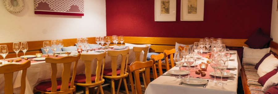 Comfortably laid table in a restaurant with wine glasses, candles and wooden furniture. The walls are decorated in red and white., &copy; 70469R! Weinbau Fabian Rajtschan