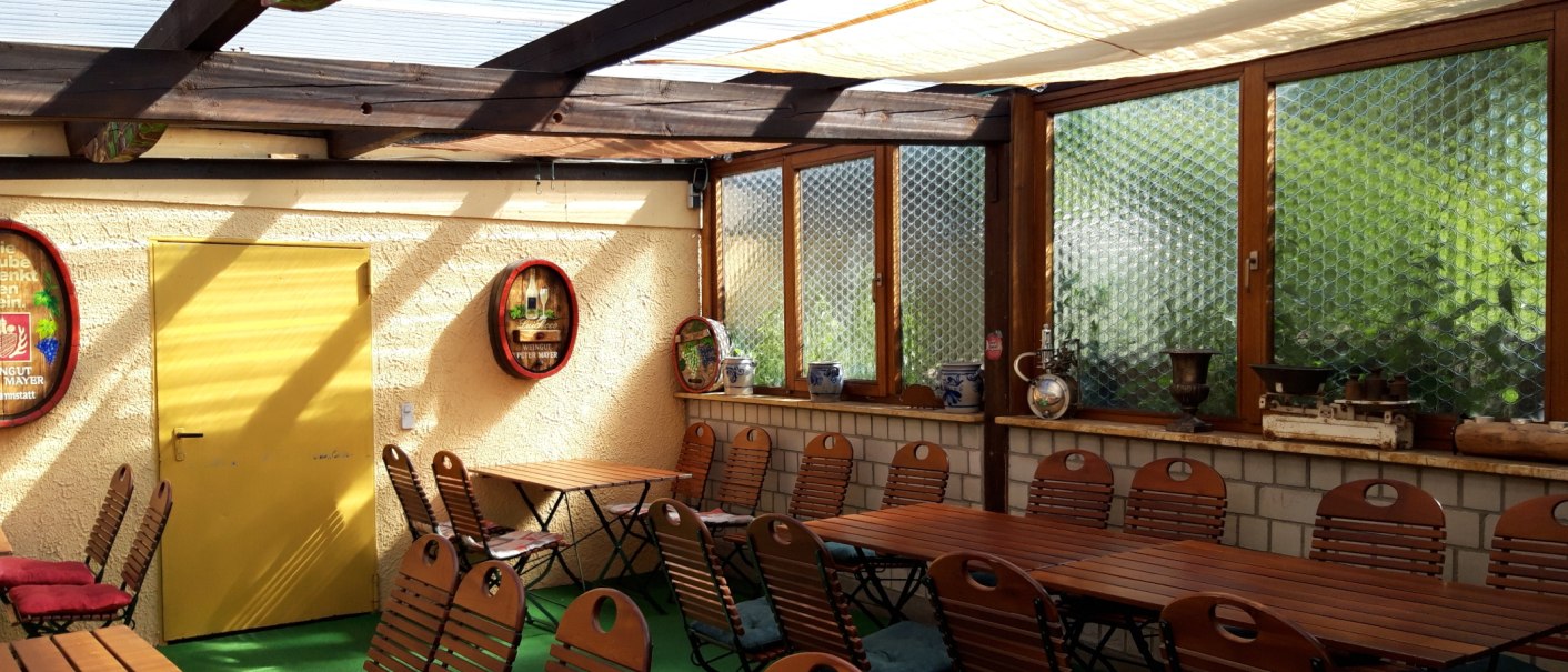 Cozy wine bar with wooden tables and chairs, yellow door, decorative barrels and windows with glass bricks., © Weinstube Jägerhof Cozy wine bar with wooden tables and chairs, yellow door, decorative barrels and windows with glass bricks., © Weinstube Jägerhof