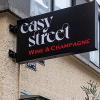 Ein Schild mit der Aufschrift 'easy street Wine & Champagne' h&auml;ngt an einer Geb&auml;udewand. Darunter ist eine Hausnummer zu sehen., &copy; Stuttgart-Marketing GmbH, Sarah Schmid