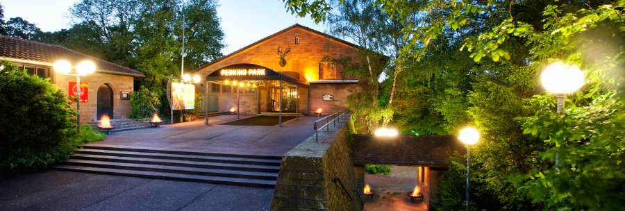 Entrance to Perkins Park in Stuttgart at dusk, surrounded by trees and illuminated with lanterns., &copy; PerkinsPark