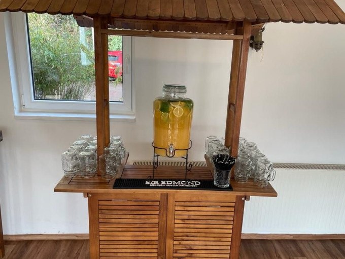 Holztisch mit Limonadenspender, Gläsern und Strohhalmen vor einem Fenster., © Cool-Tours StattReisen Holztisch mit Limonadenspender, Gläsern und Strohhalmen vor einem Fenster., © Cool-Tours StattReisen