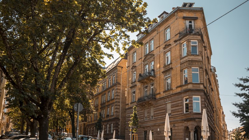 Historisches Gebäude an einer Straßenecke, umgeben von Bäumen und geparkten Autos. Sonniger Tag mit klarem Himmel., © SMG Stuttgart Marketing GmbH - Sarah Schmid Historisches Gebäude an einer Straßenecke, umgeben von Bäumen und geparkten Autos. Sonniger Tag mit klarem Himmel., © SMG Stuttgart Marketing GmbH - Sarah Schmid