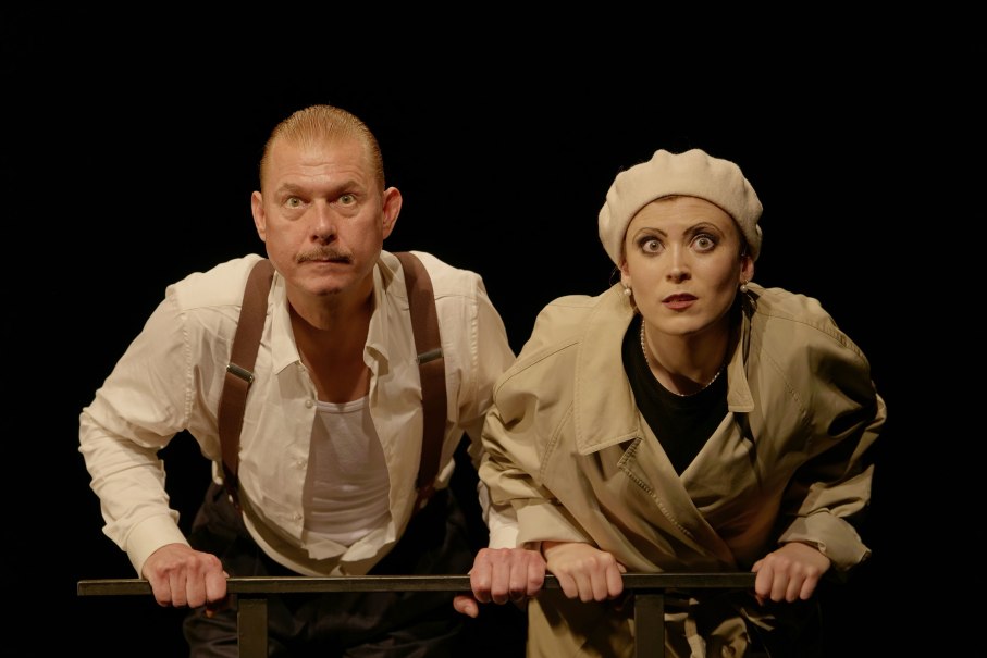 Zwei Personen in Theaterkostümen schauen gespannt nach vorne. Der Mann trägt Hosenträger, die Frau einen Hut. Der Hintergrund ist schwarz., © Theater tri-bühne, Anton Avdieiev Zwei Personen in Theaterkostümen schauen gespannt nach vorne. Der Mann trägt Hosenträger, die Frau einen Hut. Der Hintergrund ist schwarz., © Theater tri-bühne, Anton Avdieiev