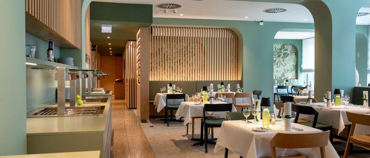 Elegant breakfast room with laid tables, green walls and wooden elements. Modern design with natural light and stylish decoration., © Erikson Hotel