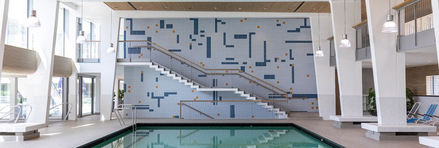 Modern swimming pool with rectangular pool, steps and mosaic wall. Bright lighting and large windows create a friendly atmosphere., © Stuttgarter Bäder