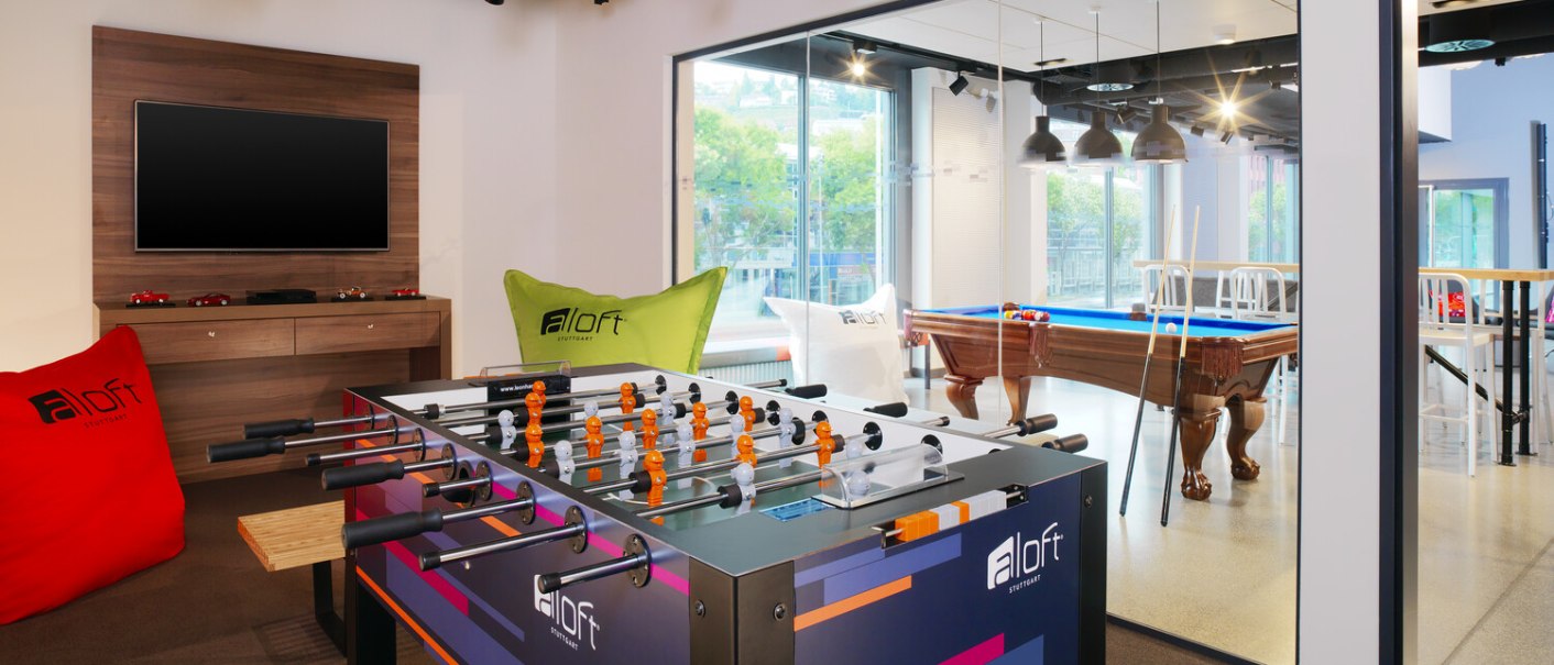 Ein stilvoller Lounge-Bereich mit Tischfußball, Billardtisch und Sitzsäcken. Große Fenster lassen viel Licht herein. Perfekt für Freizeit und Entspannung., © Aloft Stuttgart Ein stilvoller Lounge-Bereich mit Tischfußball, Billardtisch und Sitzsäcken. Große Fenster lassen viel Licht herein. Perfekt für Freizeit und Entspannung., © Aloft Stuttgart
