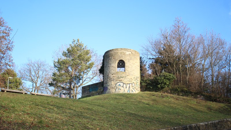 Eine alte, runde Ruine mit Graffiti steht auf einem grasbewachsenen H&uuml;gel, umgeben von kahlen B&auml;umen und blauem Himmel., &copy; SMG