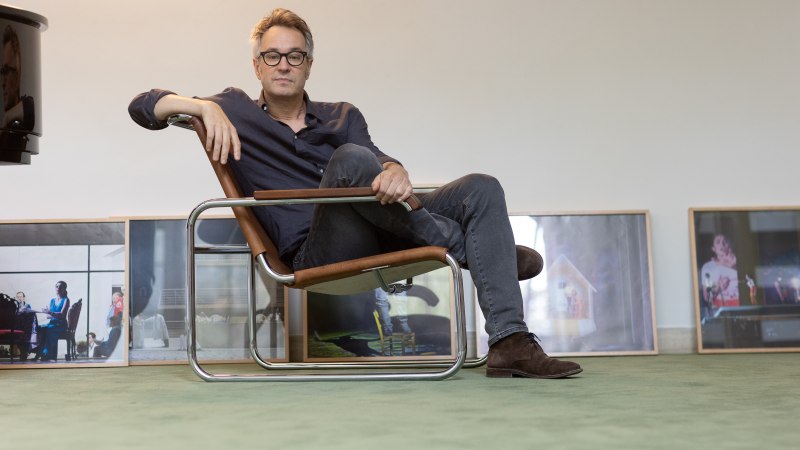 Eine Person sitzt entspannt in einem modernen Stuhl. Im Hintergrund stehen gerahmte Bilder auf dem Boden. Die Atmosph&auml;re wirkt k&uuml;nstlerisch und gelassen., &copy; Alberto Novelli