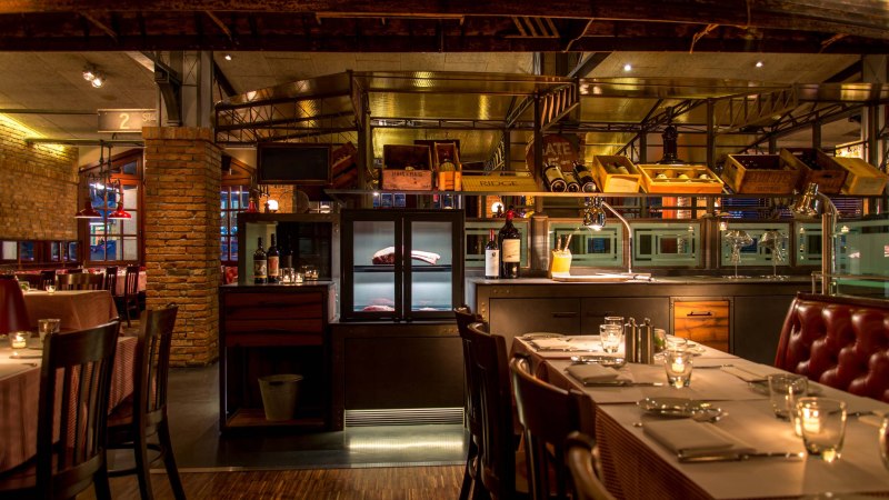 Stylish restaurant with brick walls, laid tables and bottles of wine. Warm light creates a cozy atmosphere., &copy; &copy;Pier 51