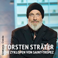 Ein Mann mit Bart und Mütze vor unscharfem Hintergrund. Text: Torsten Sträter - Die Zyklopen von Saint-Tropez., © links im Bild