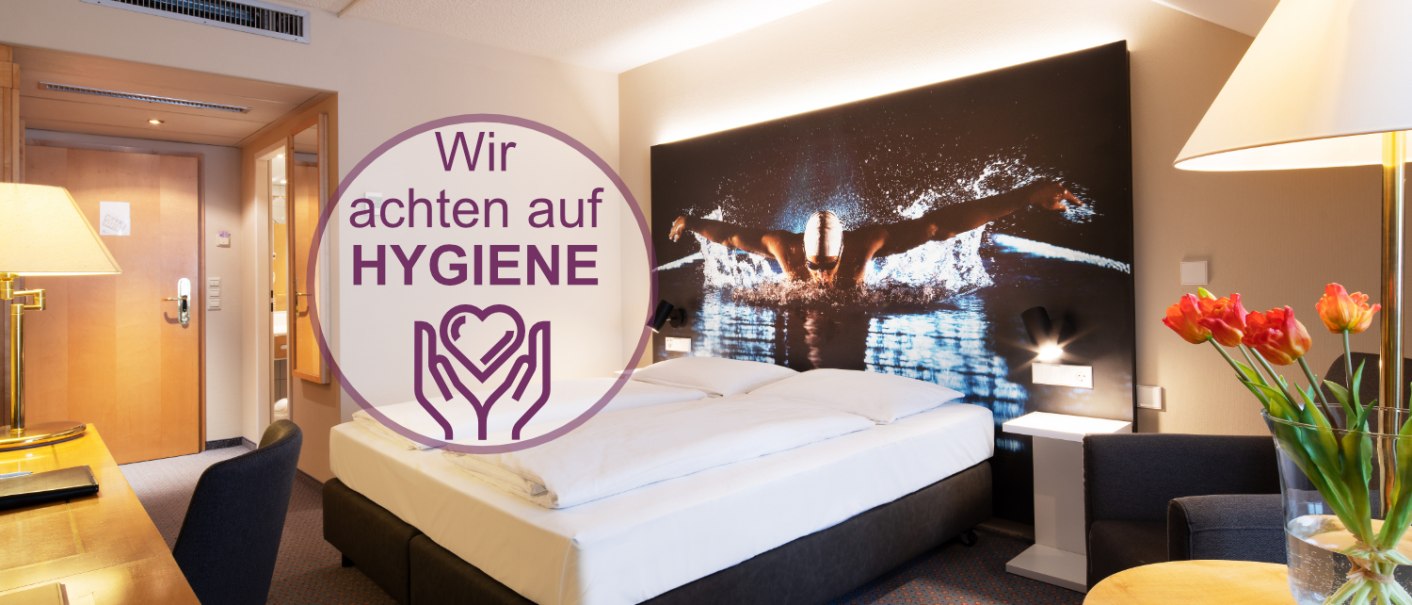 Modern hotel room with double bed, large picture of a swimmer on the wall, table with flowers and hygiene instructions., &copy; Erikson Hotel