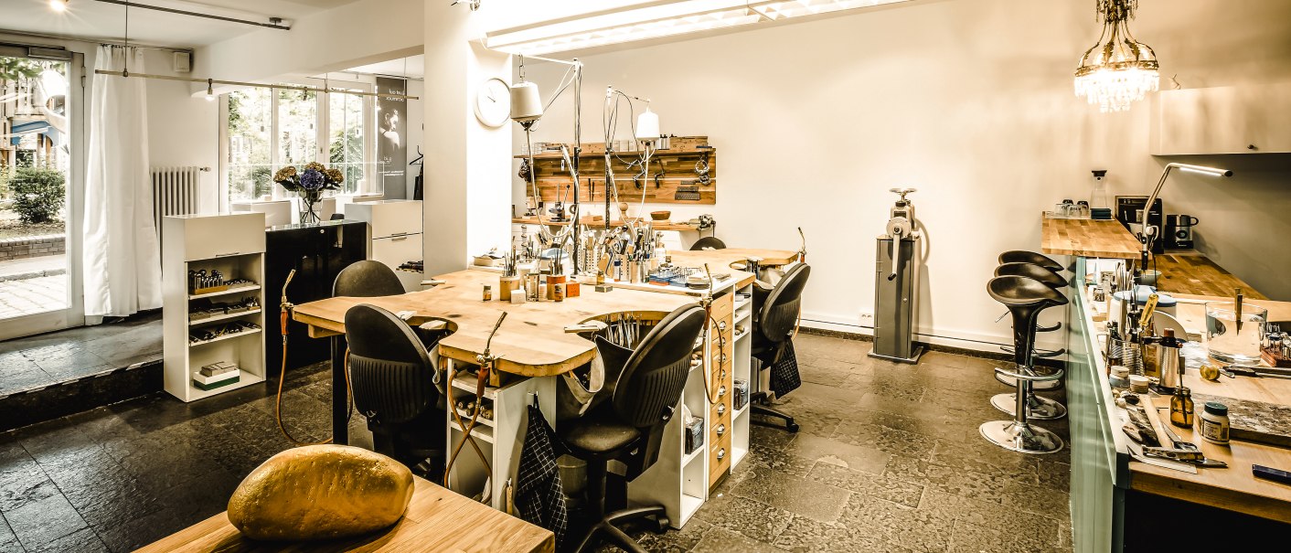 Moderne Werkstatt mit Holztischen, Werkzeugen und St&uuml;hlen. Helle Beleuchtung und gro&szlig;e Fenster sorgen f&uuml;r eine einladende Atmosph&auml;re., &copy; Goldmond