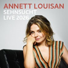 Frau auf schwarzem Sofa, gestreiftes Oberteil. Text: Annett Louisan - Sehnsucht - Live 2026., © links im Bild Frau auf schwarzem Sofa, gestreiftes Oberteil. Text: Annett Louisan - Sehnsucht - Live 2026., © links im Bild