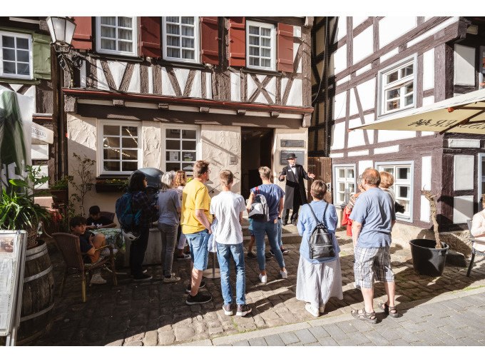 Eine Gruppe von Menschen lauscht einem Führer vor einem historischen Fachwerkhaus. Die Szene spielt sich bei sonnigem Wetter ab., © Eigenbetrieb Tourismus und Citymanagement Schorndorf Eine Gruppe von Menschen lauscht einem Führer vor einem historischen Fachwerkhaus. Die Szene spielt sich bei sonnigem Wetter ab., © Eigenbetrieb Tourismus und Citymanagement Schorndorf
