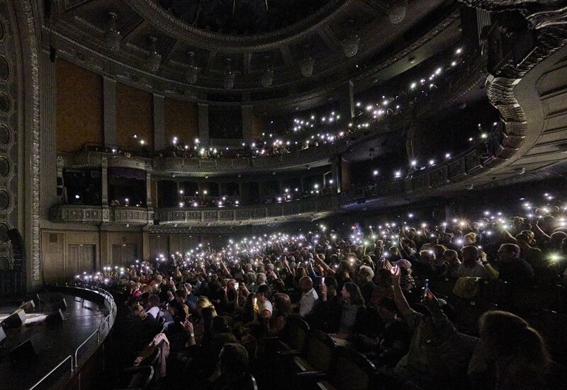 Ein volles Theater mit Publikum, das leuchtende Handys hochhält, schafft eine stimmungsvolle Atmosphäre. Die Architektur ist klassisch und beeindruckend., © Württembergische Staatstheater Stuttgart Ein volles Theater mit Publikum, das leuchtende Handys hochhält, schafft eine stimmungsvolle Atmosphäre. Die Architektur ist klassisch und beeindruckend., © Württembergische Staatstheater Stuttgart