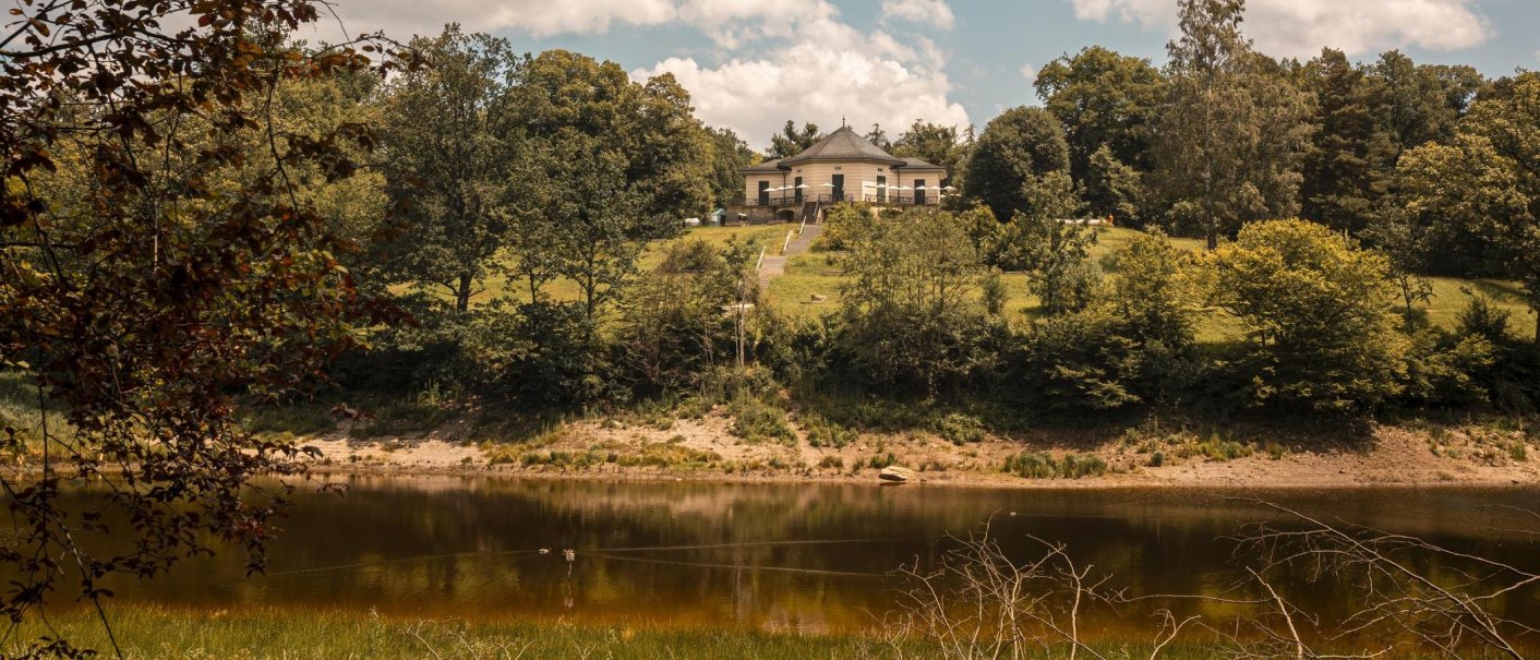 Das Bärenschlössle thront auf einem grünen Hügel am Bärensee, umgeben von üppigen Bäumen und einem klaren Himmel mit weißen Wolken., © SMG, Sarah Schmid Das Bärenschlössle thront auf einem grünen Hügel am Bärensee, umgeben von üppigen Bäumen und einem klaren Himmel mit weißen Wolken., © SMG, Sarah Schmid