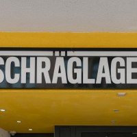 Entrance to the Schr&auml;glage Club with yellow fa&ccedil;ade and black sign. CD logos with ears of corn are depicted on the left and right., &copy; Stuttgart Marketing GmbH, Sarah Schmid