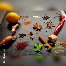 Verschiedene Gewürze und Zutaten wie Zitrone, Chili, Ingwer und Safran auf dunkler Oberfläche. Text: "Gewürze für die orientalische Küche"., © links im Bild Verschiedene Gewürze und Zutaten wie Zitrone, Chili, Ingwer und Safran auf dunkler Oberfläche. Text: "Gewürze für die orientalische Küche"., © links im Bild