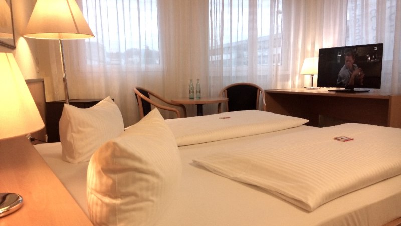 Gemütliches Doppelzimmer mit Doppelbett, Schreibtisch, Stuhl und Fernseher. Große Fenster mit Vorhängen., © Central Hotel Gemütliches Doppelzimmer mit Doppelbett, Schreibtisch, Stuhl und Fernseher. Große Fenster mit Vorhängen., © Central Hotel