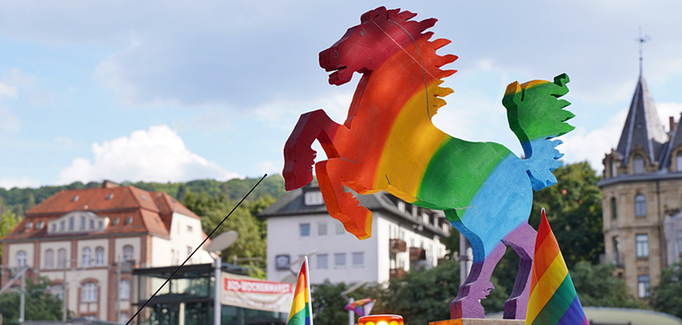 Ein Regenbogen-Pferd aus Pappe vor historischen Geb&auml;uden und blauem Himmel bei der Stuttgart PRIDE., &copy; IG CSD Stuttgart e.V.