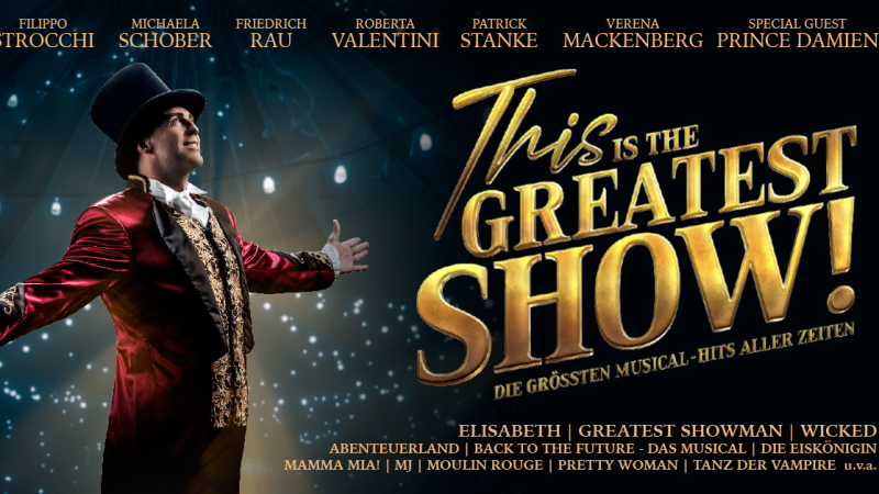 Ein Mann in einem roten Frack und Zylinder steht auf einer Bühne mit ausgebreiteten Armen. Der Text "This is THE GREATEST SHOW!" ist groß im Bild., © links im Bild Ein Mann in einem roten Frack und Zylinder steht auf einer Bühne mit ausgebreiteten Armen. Der Text "This is THE GREATEST SHOW!" ist groß im Bild., © links im Bild