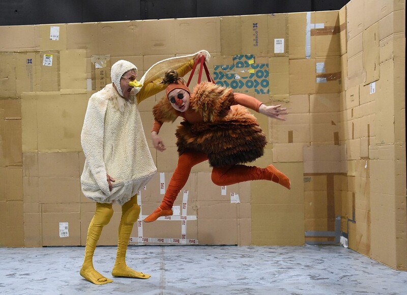 Zwei Personen in Tierkost&uuml;men, eine als Ente und eine als Huhn, agieren in einem Raum mit Pappkartonw&auml;nden. Humorvolle Szene., &copy; Theaterhaus Stuttgart e.V.