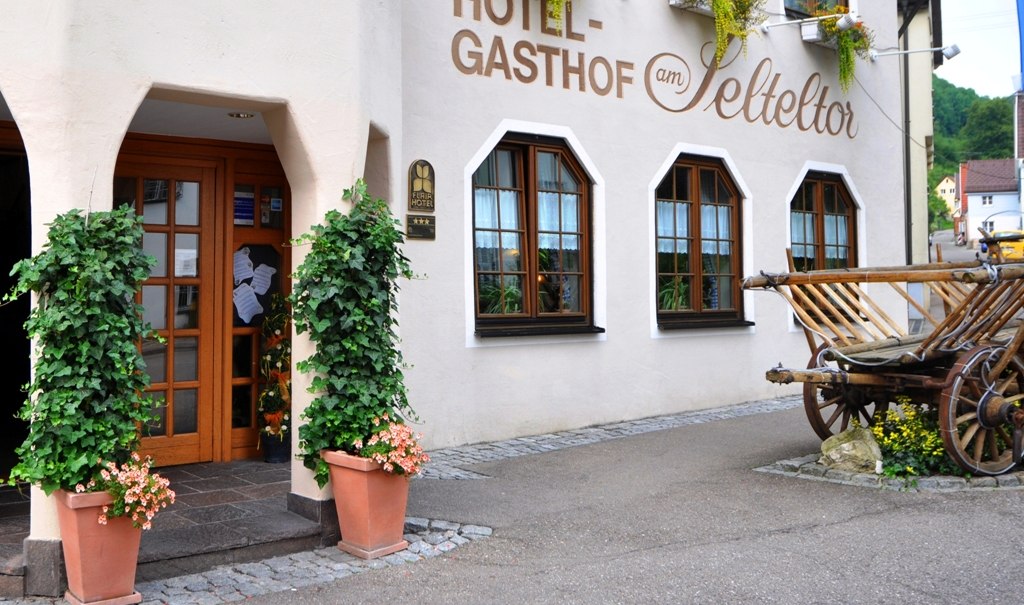 Eingang des Hotel-Gasthofs am Selteltor mit Pflanzen geschmückt. Ein alter Holzwagen steht daneben., © R.Storr Eingang des Hotel-Gasthofs am Selteltor mit Pflanzen geschmückt. Ein alter Holzwagen steht daneben., © R.Storr
