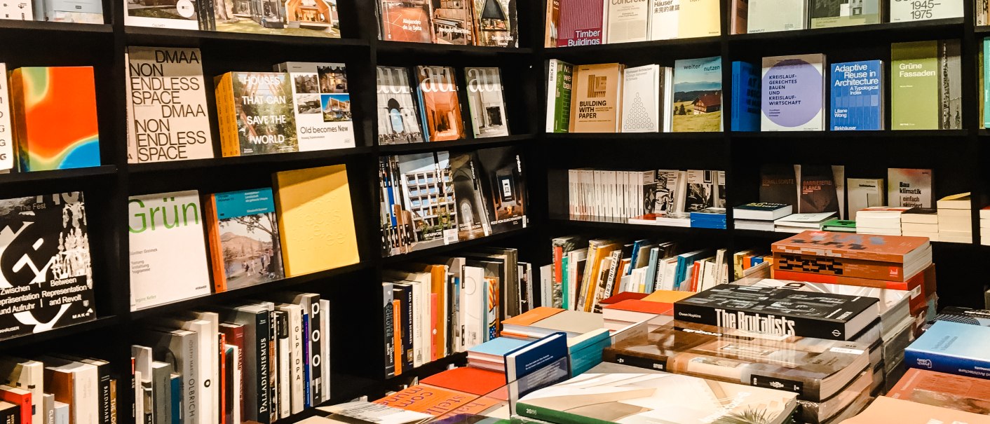 B&uuml;cherregale in einer Buchhandlung mit einer Vielzahl von B&uuml;chern zu Architektur und Kunst. Stapel von B&uuml;chern auf einem Tisch in der Mitte., &copy; Walther K&ouml;nig