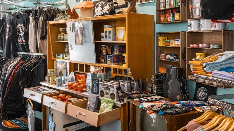 Ein Retro-Laden mit T-Shirts, Jacken und Vintage-Artikeln. Regale voller bunter Produkte und ein Kleiderständer mit verschiedenen Kleidungsstücken., © SMG, Sarah Schmid Ein Retro-Laden mit T-Shirts, Jacken und Vintage-Artikeln. Regale voller bunter Produkte und ein Kleiderständer mit verschiedenen Kleidungsstücken., © SMG, Sarah Schmid