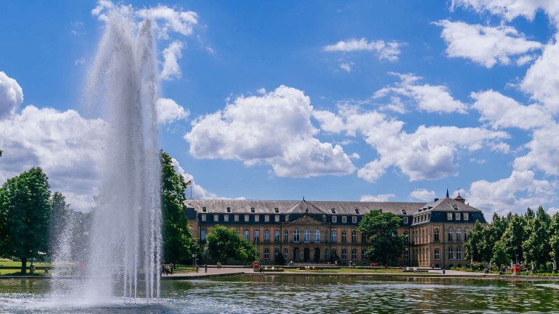 Das Bild zeigt das Neue Schloss in Stuttgart mit einem gro&szlig;en Springbrunnen im Vordergrund und dem Eckensee. Der Himmel ist blau mit wei&szlig;en Wolken., &copy; Thomas Niederm&uuml;ller