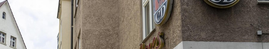 A building with the lettering 'Mrs Jones' and a logo with ears of corn and the letters 'CD'. A parasol is visible in the foreground., &copy; SMG, Sarah Schmid