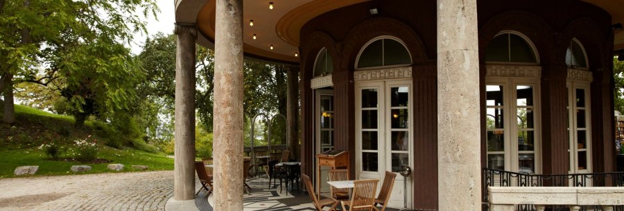The teahouse in Stuttgart's Weissenburgpark features elegant architecture with columns and a cozy outdoor seating area., © Stuttgart-Marketing GmbH Christoph Düpper
