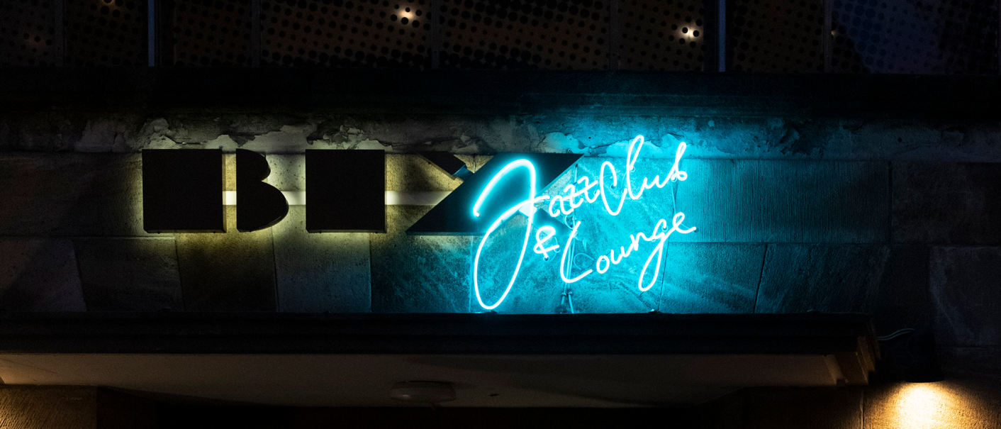 Leuchtendes Neonschild des BIX Jazzclub & Lounge in Blau und Weiß an einer dunklen Wand., © Stuttgart-Marketing GmbH, Alwin Maigler