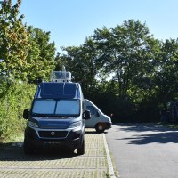 Wohnmobilstellplatz in Böblingen mit geparkten Wohnmobilen, umgeben von Bäumen und sonnigem Wetter., © Stadtmarketing Böblingen e. V.
