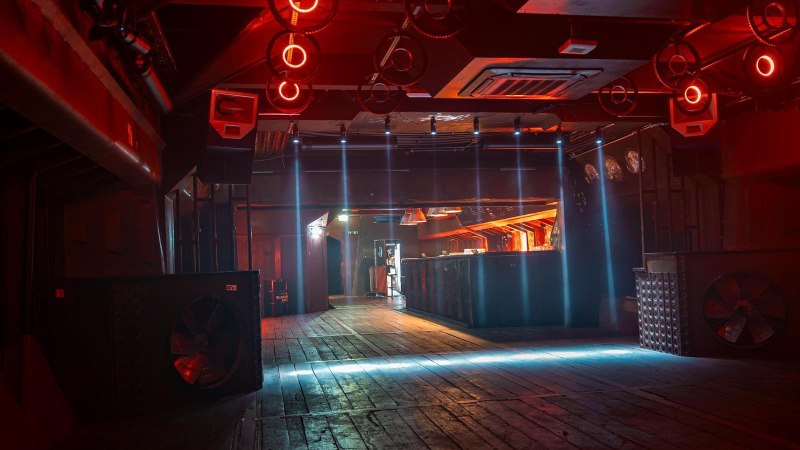 Ein leerer Nachtclub mit roter Beleuchtung, Holzboden und futuristischer Decke. Die Bar im Hintergrund ist beleuchtet., &copy; Stuttgart-Marketing GmbH, Sarah Schmid