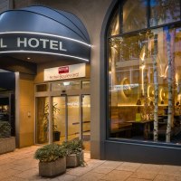 Au&szlig;enansicht eines Hotels mit beleuchtetem Eingang, gro&szlig;em Fenster und Pflanzen. Schild mit der Aufschrift 'Hotel Boulevard' &uuml;ber der T&uuml;r., &copy; Novum Hospitality
