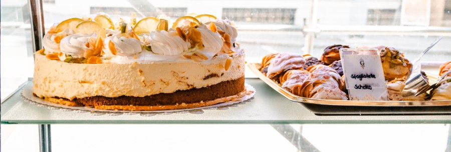Eine Vitrine zeigt eine Zitronentorte und verschiedene Gebäcksorten wie Sfogliatelle mit Zitronen- und weißer Schokolade in einem Café., © SMG, Sarah Schmid Eine Vitrine zeigt eine Zitronentorte und verschiedene Gebäcksorten wie Sfogliatelle mit Zitronen- und weißer Schokolade in einem Café., © SMG, Sarah Schmid