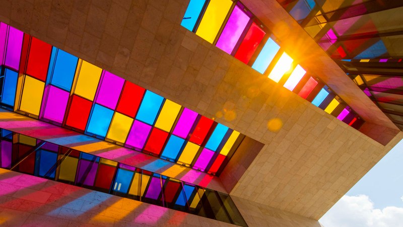 Stained glass windows in a modern building cast colorful shadows on the walls. Sunlight shines through the windows., © © Stuttgart-Marketing GmbH Stained glass windows in a modern building cast colorful shadows on the walls. Sunlight shines through the windows., © © Stuttgart-Marketing GmbH